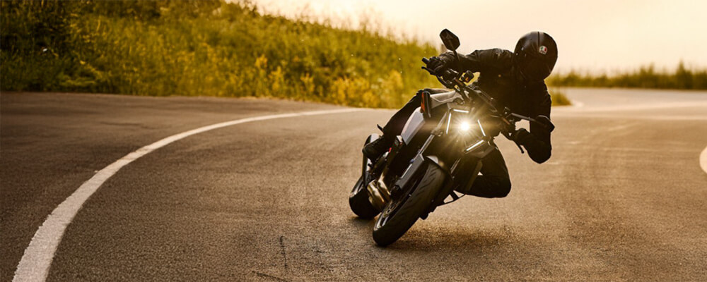 Motorradfahrer in Kurve auf Landstraße